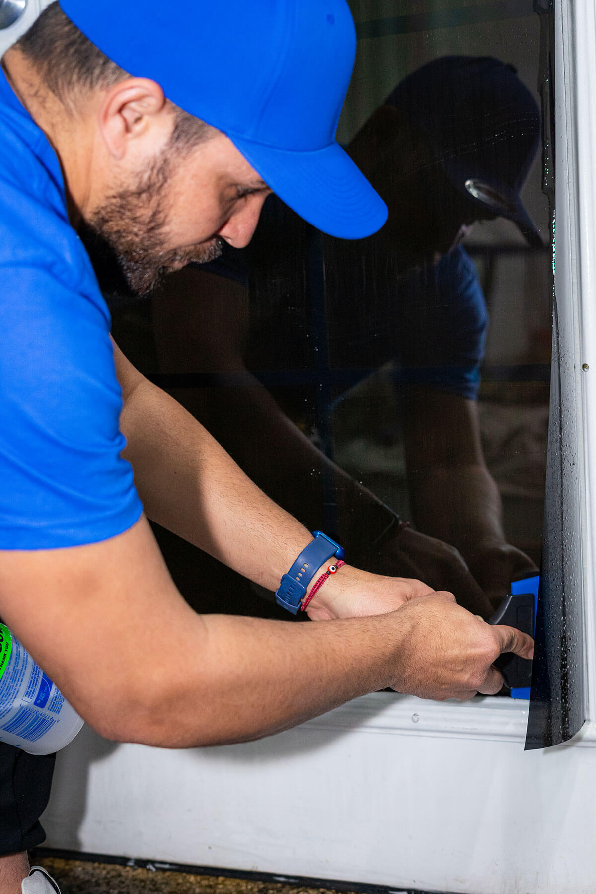 Anti-graffiti sacrificial film applied to a vulnerable retail storefront window — clear protective layer being installed