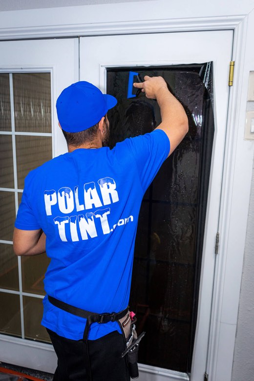 Polar Tint installer applying window film to building glass