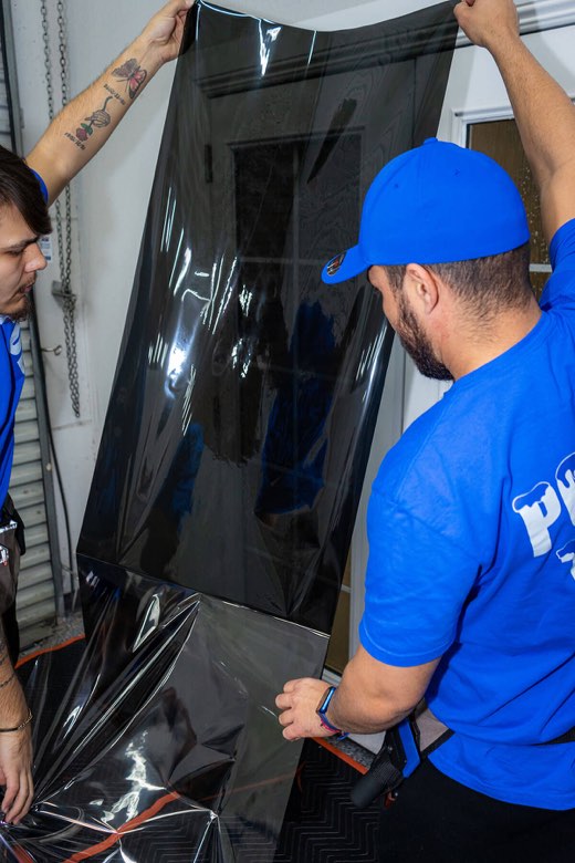 Polar Tint team fitting window film on a glass door
