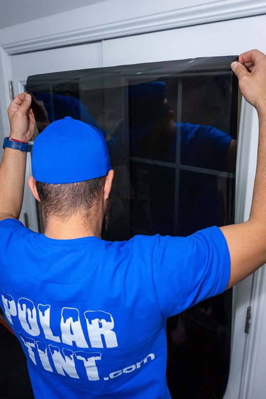 Window film being applied to a glass door by Polar Tint