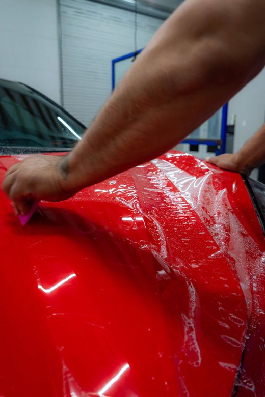 Paint protection film being applied to a vehicle