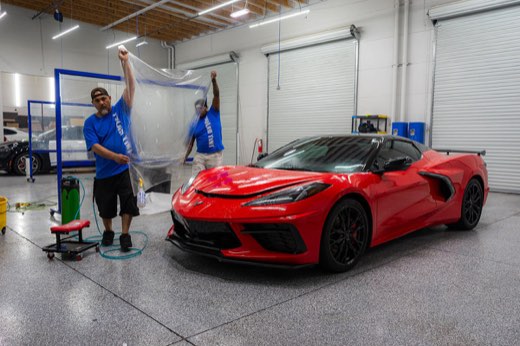 Installer fitting paint protection film on a vehicle